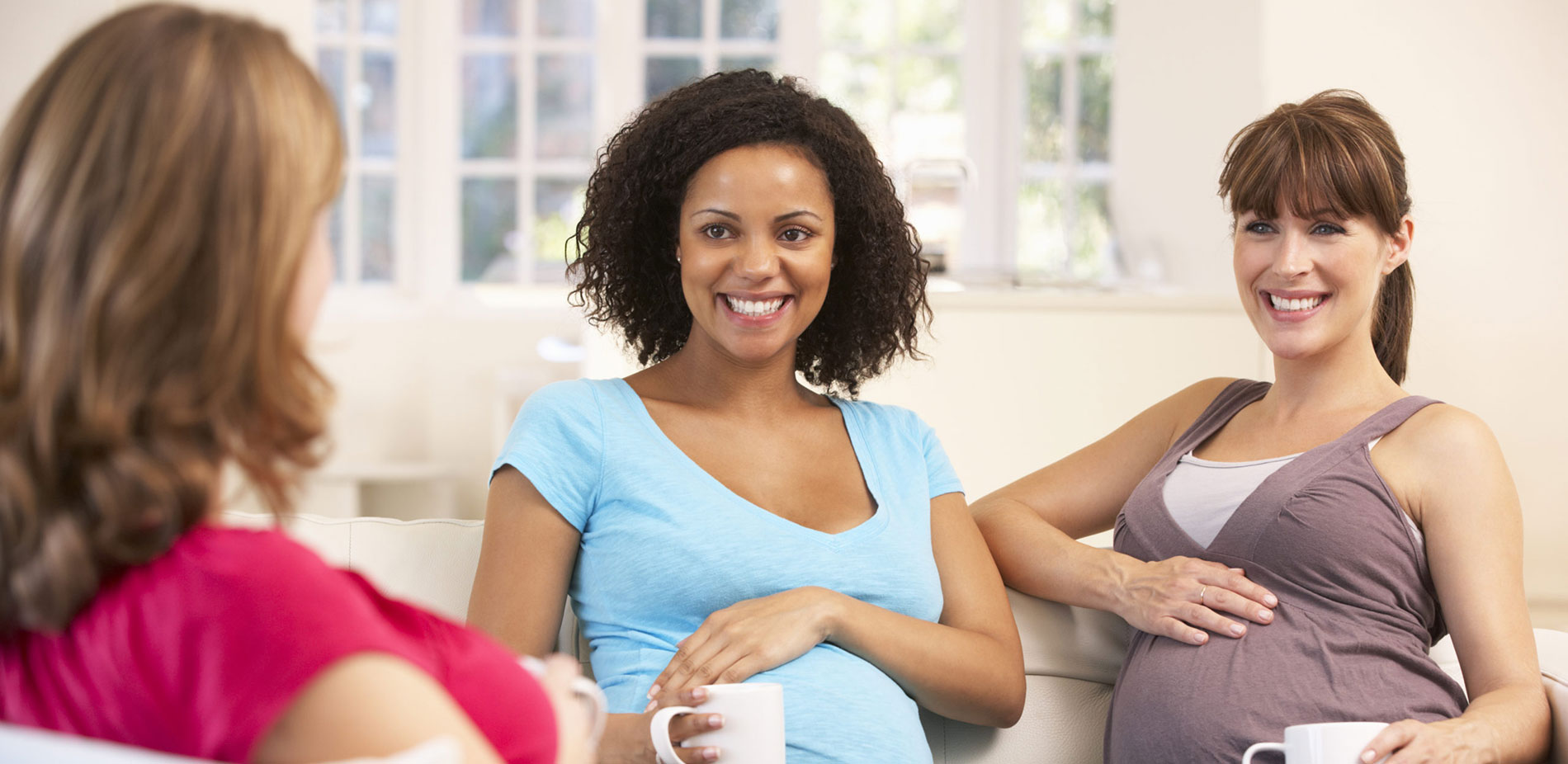 Pregnant women visiting and having tea.