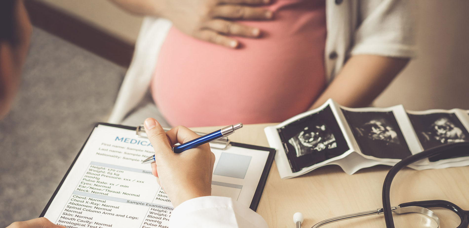 Doctor has consultation with pregnant patient.