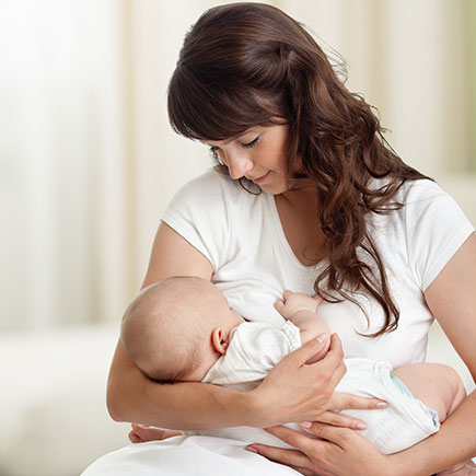 Mother breastfeeding with help from lactation services